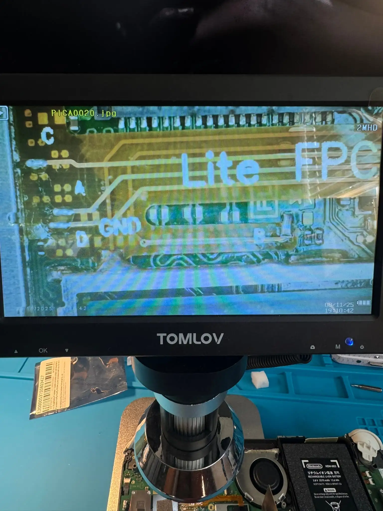 Alvaro's workbench: a digital microscope showing a Switch board mid-install